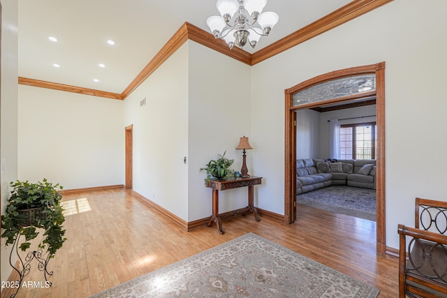 hall with light wood-type flooring, baseboards, and crown molding