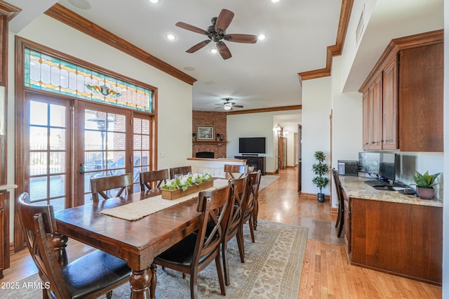 dining area with light wood finished floors, baseboards, crown molding, a brick fireplace, and recessed lighting