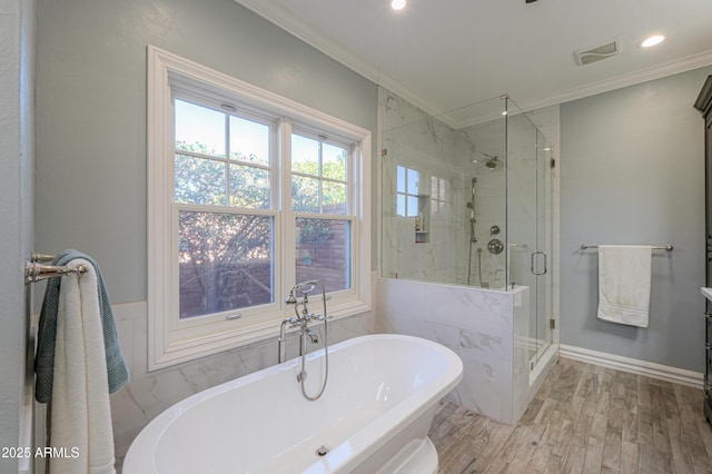 bathroom with a soaking tub, a marble finish shower, visible vents, and crown molding