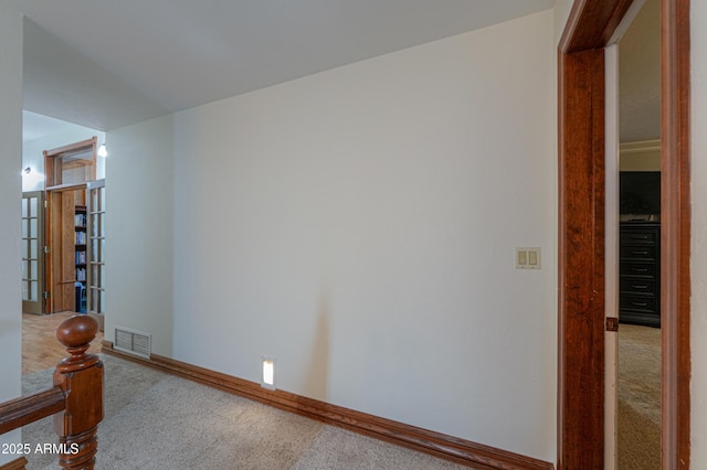 empty room with carpet floors, baseboards, and visible vents