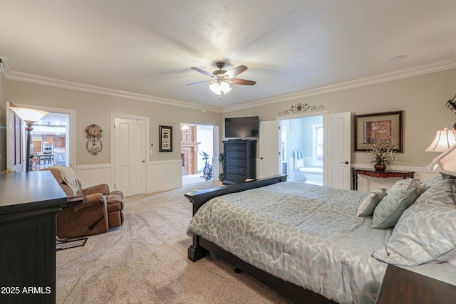 bedroom featuring light carpet, a ceiling fan, crown molding, and wainscoting