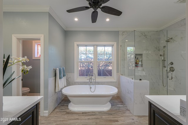 full bathroom featuring tile walls, vanity, wainscoting, a soaking tub, and crown molding