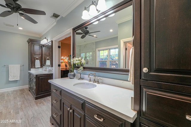 full bath featuring ornamental molding, two vanities, a sink, and visible vents