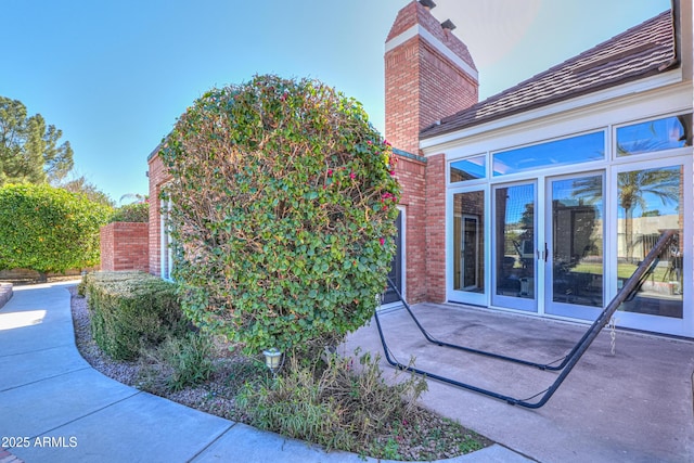 view of side of property featuring a patio area and a chimney