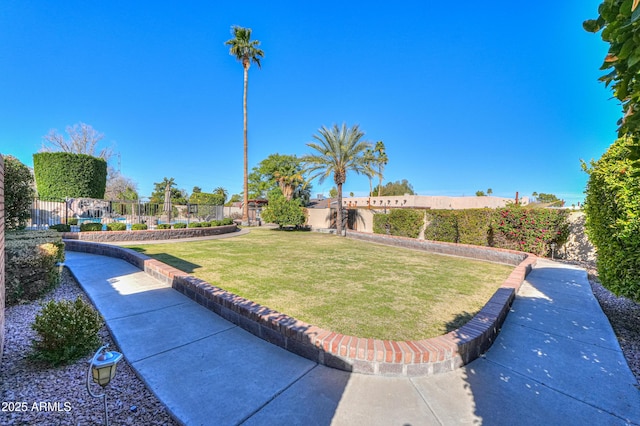 view of community featuring fence and a yard