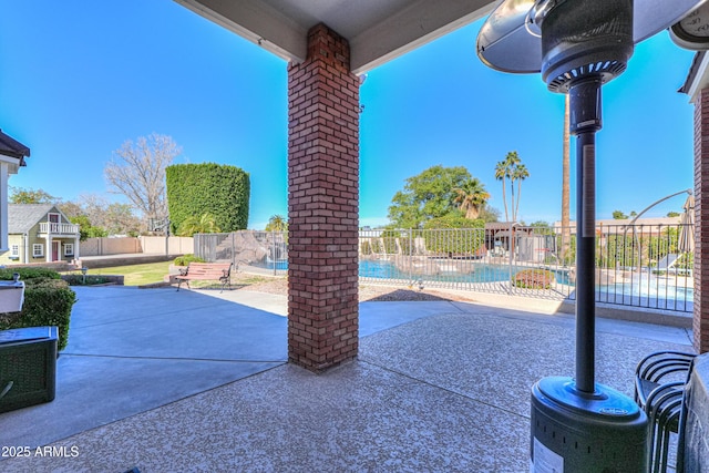 view of patio featuring a fenced backyard and a community pool