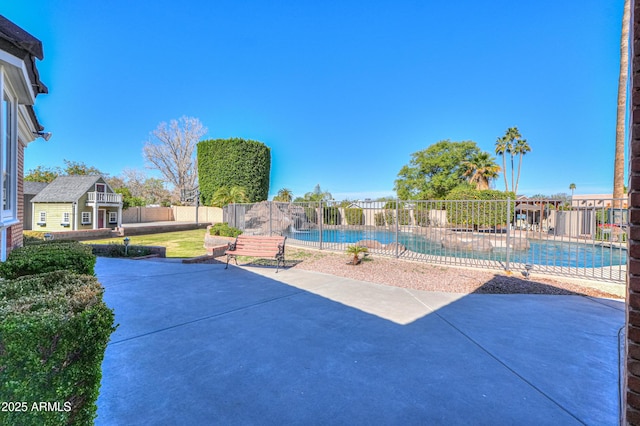 view of patio / terrace with a fenced in pool, fence, and an outdoor structure