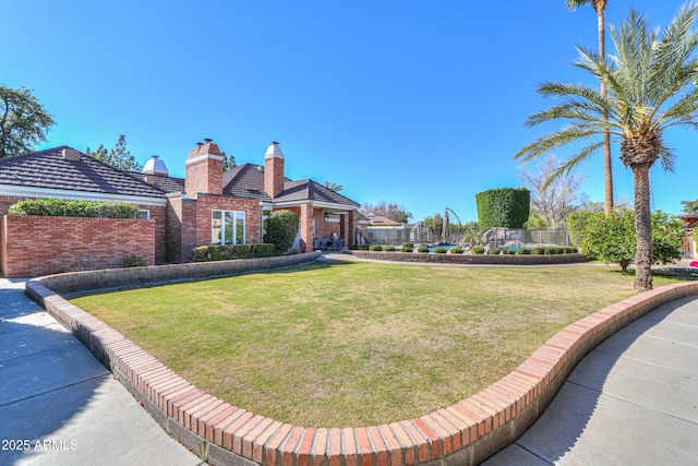 exterior space with brick siding, a chimney, and a front lawn