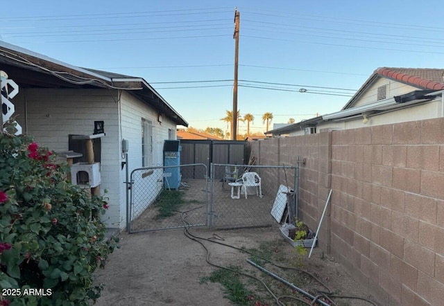 property exterior at dusk with a gate and fence