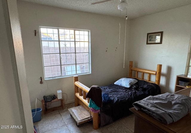 bedroom featuring ceiling fan, a textured ceiling, and tile patterned floors