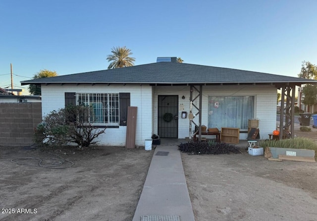 view of front of home featuring fence and brick siding