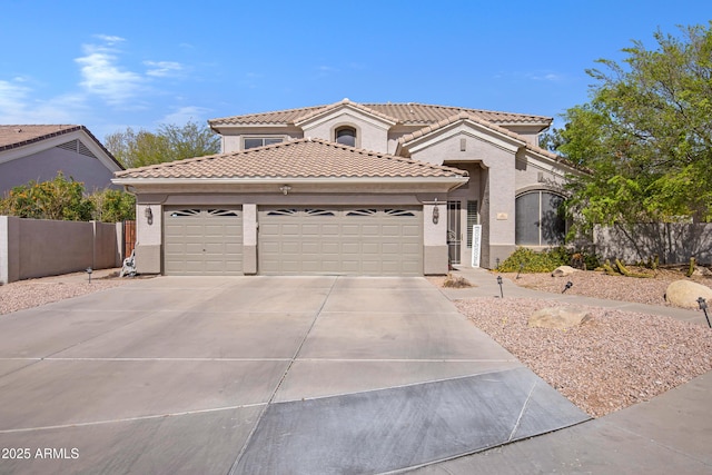 mediterranean / spanish-style home featuring an attached garage, fence, a tile roof, concrete driveway, and stucco siding