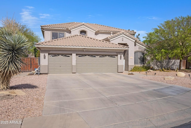 mediterranean / spanish-style home with a garage, concrete driveway, a tile roof, fence, and stucco siding