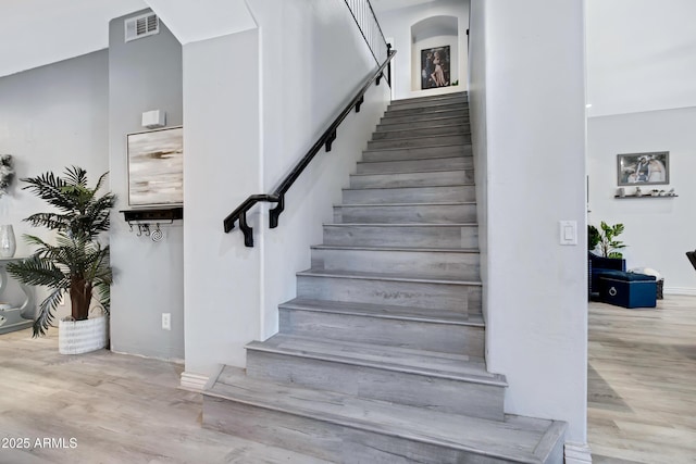 stairs with visible vents and wood finished floors