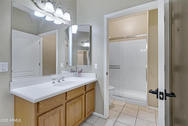 bathroom featuring tile patterned flooring, toilet, vanity, baseboards, and a shower stall