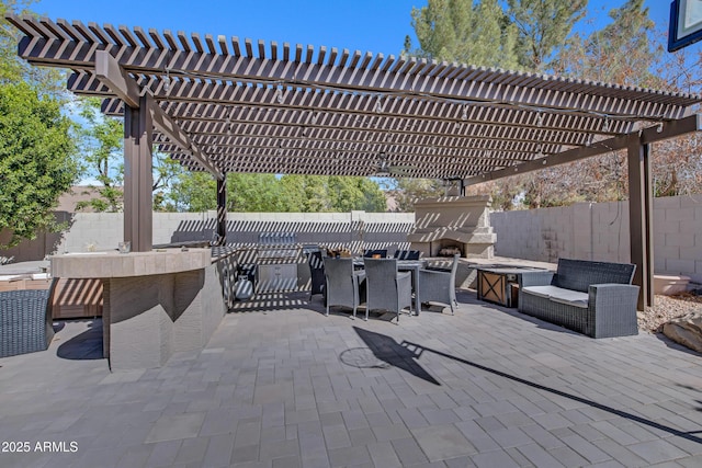 view of patio / terrace with a fenced backyard, exterior fireplace, a pergola, and outdoor dining space