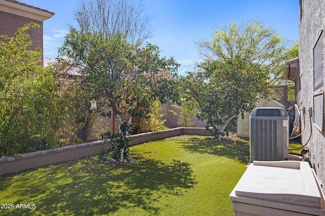 view of yard with a fenced backyard and central AC