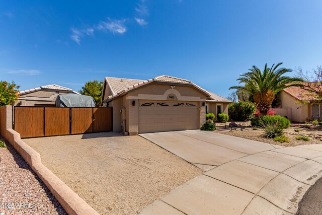 24813 N 55th Dr, Glendale, AZ 85310 - view of front of home with concrete driveway, stucco siding, an attached garage, a tile roof, and a gate