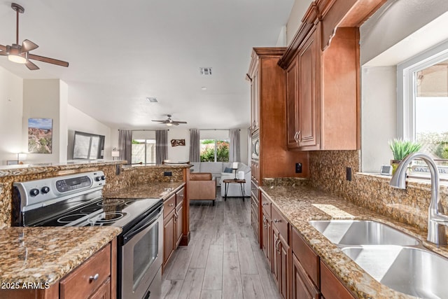 24813 N 55th Dr, Glendale, AZ 85310 - kitchen featuring appliances with stainless steel finishes, ceiling fan, a sink, brown cabinets, and open floor plan