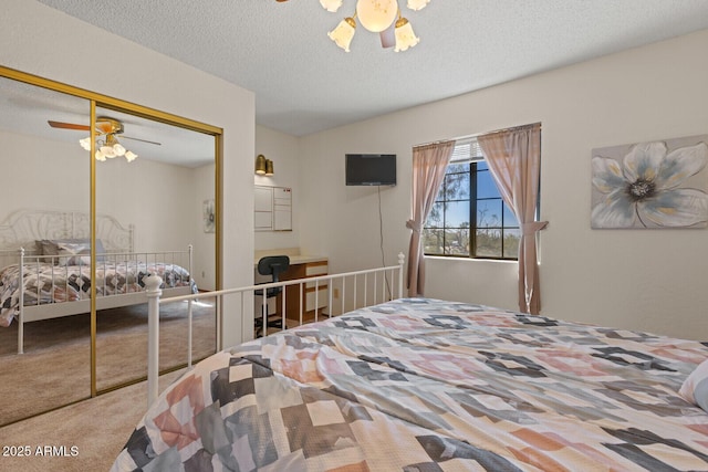 carpeted bedroom with ceiling fan, a textured ceiling, and a closet