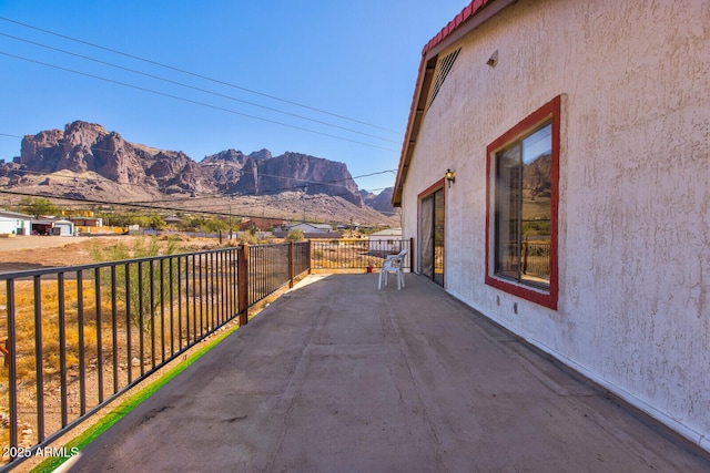 exterior space with a mountain view, a balcony, and stucco siding