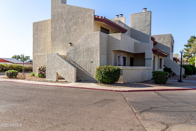 view of property exterior with a chimney and stucco siding