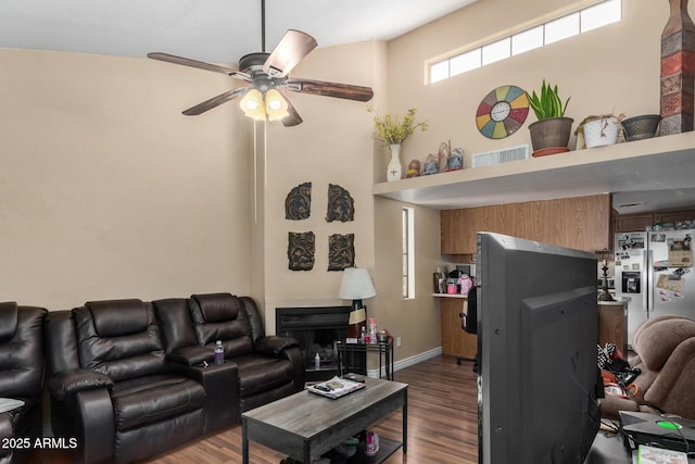 living area featuring baseboards, a ceiling fan, wood finished floors, and visible vents