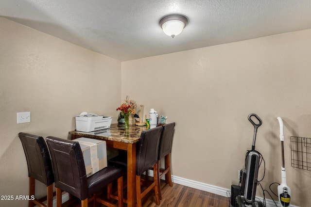 dining area with baseboards and dark wood-style floors