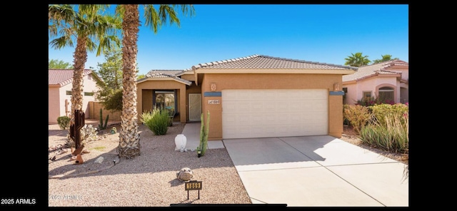 view of front of property with driveway, a tiled roof, an attached garage, and stucco siding