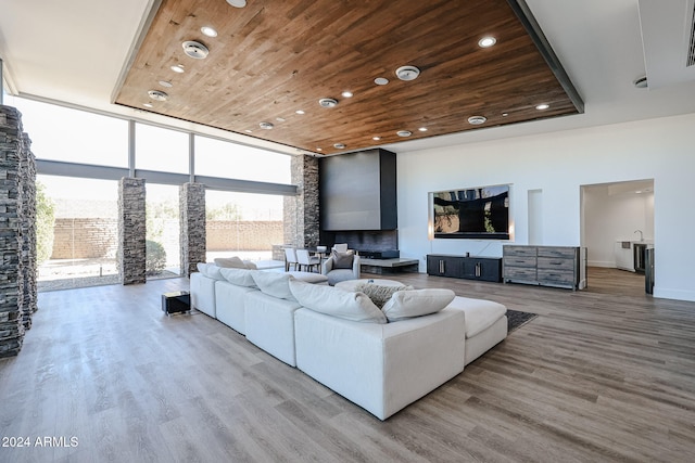 living room with a healthy amount of sunlight, wood-type flooring, and wooden ceiling