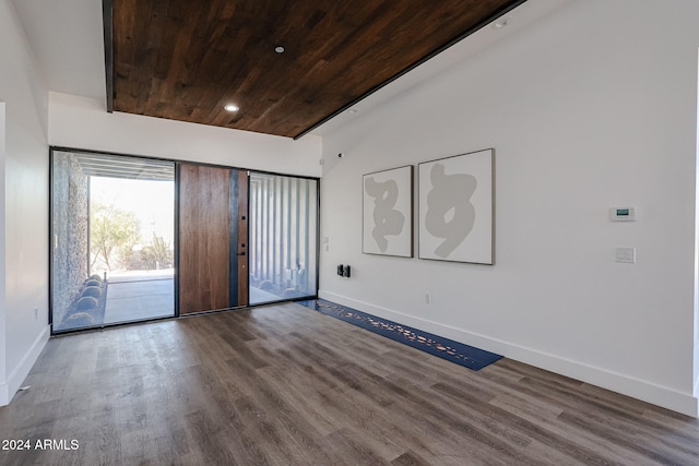 spare room featuring wood ceiling, wood-type flooring, and vaulted ceiling