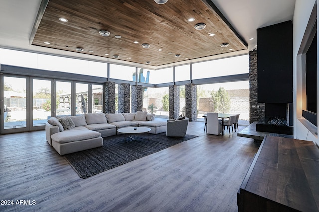 living room featuring wood-type flooring, wooden ceiling, and plenty of natural light