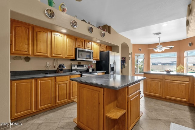 kitchen featuring a kitchen island, appliances with stainless steel finishes, plenty of natural light, and ceiling fan