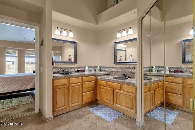 bathroom with ceiling fan, vanity, and backsplash