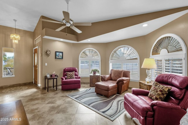 living room with ceiling fan with notable chandelier and light tile patterned floors