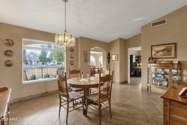 dining area with vaulted ceiling and light tile patterned floors