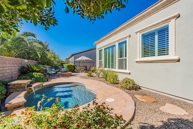 view of swimming pool featuring pool water feature and a patio area