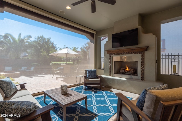 view of patio featuring ceiling fan and an outdoor living space with a fireplace