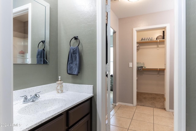 1706 W Coolidge Way, Coolidge, AZ 85128 - bathroom featuring tile patterned flooring, baseboards, a spacious closet, and vanity