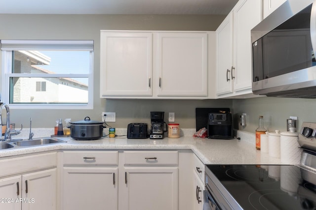 1706 W Coolidge Way, Coolidge, AZ 85128 - kitchen featuring electric range oven, stainless steel microwave, and white cabinetry