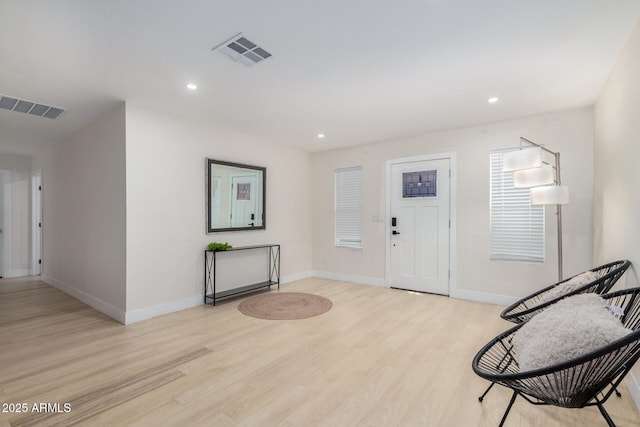 foyer with recessed lighting, baseboards, light wood finished floors, and visible vents