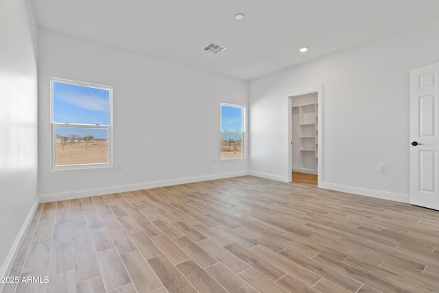 1222 S 365th Ave, Tonopah, AZ 85354 - unfurnished bedroom with light wood-style floors, baseboards, a walk in closet, and recessed lighting