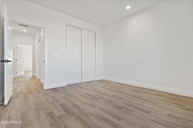 1222 S 365th Ave, Tonopah, AZ 85354 - unfurnished bedroom with light wood-style floors, baseboards, a closet, and recessed lighting