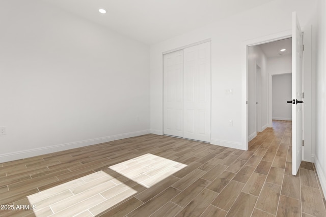 1222 S 365th Ave, Tonopah, AZ 85354 - unfurnished bedroom with wood finished floors, baseboards, a closet, and recessed lighting