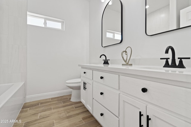 1222 S 365th Ave, Tonopah, AZ 85354 - bathroom with double vanity, toilet, baseboards, and wood finished floors