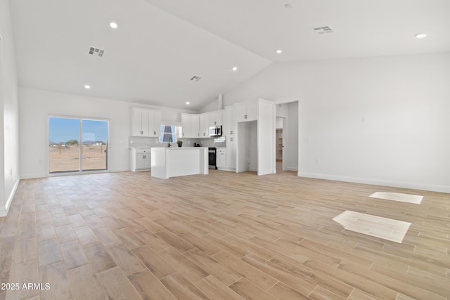 1222 S 365th Ave, Tonopah, AZ 85354 - unfurnished living room with high vaulted ceiling, light wood-style flooring, baseboards, and recessed lighting