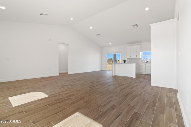 1222 S 365th Ave, Tonopah, AZ 85354 - unfurnished living room with lofted ceiling, light wood-style flooring, recessed lighting, and baseboards
