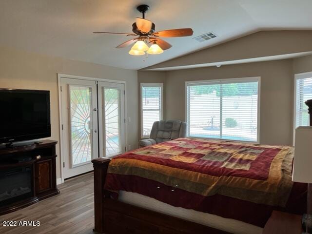 bedroom with lofted ceiling, access to exterior, hardwood / wood-style flooring, and french doors