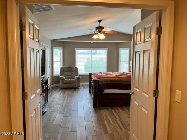 bedroom featuring lofted ceiling, dark wood-type flooring, and ceiling fan