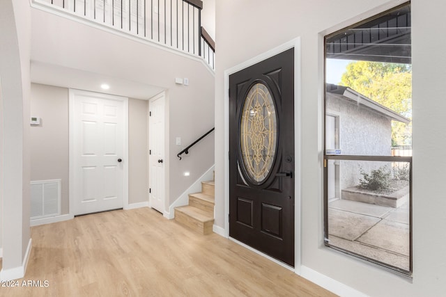 foyer entrance featuring light hardwood / wood-style floors and a high ceiling